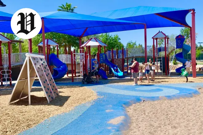 Children playing at Desert Breeze Park playground under shaded structures