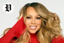 Mariah Carey smiling in a red outfit with flowing hair