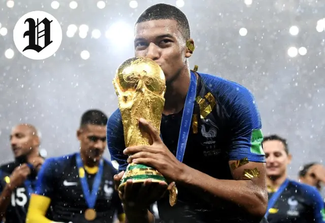 Kylian Mbappé kisses the FIFA World Cup trophy after France’s 2018 victory.