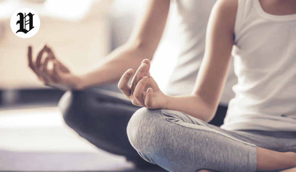 Close-up of people meditating in a cross-legged pose, practicing mindfulness and relaxation.