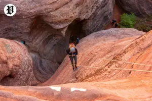 Adventurer rappelling in slot canyon near Zion National Park.