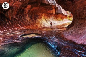 Hiker walking inside The Subway in Zion National Park.