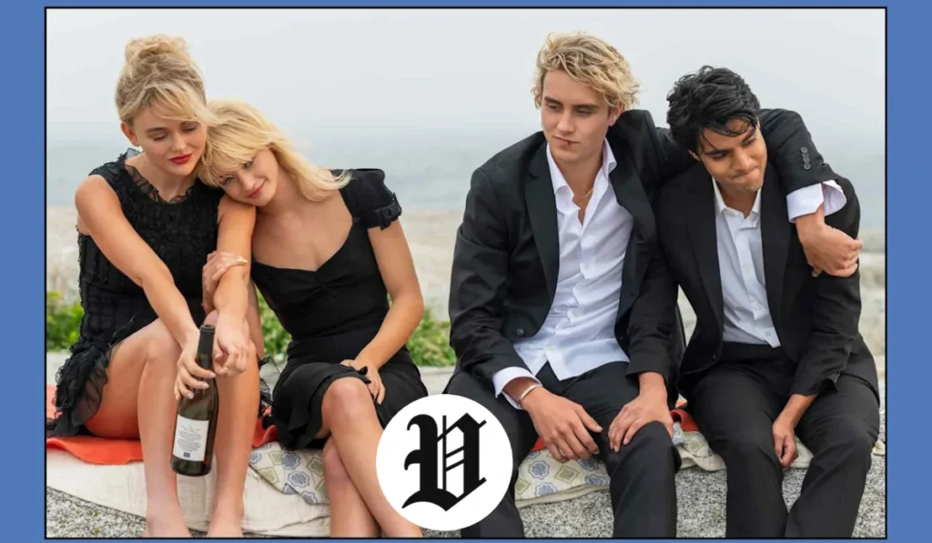 Joseph Zada sits in formal attire with friends, all dressed in black, overlooking a seaside setting.